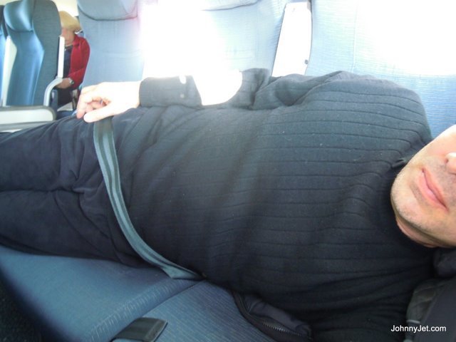 Seatbelt-over-blanket-to-sleep-on-plane