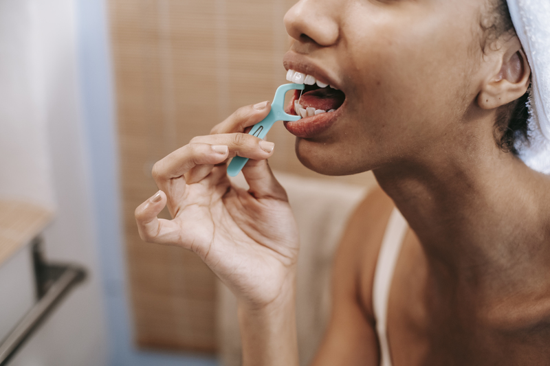 Ethnic woman cleaning teeth with dental floss