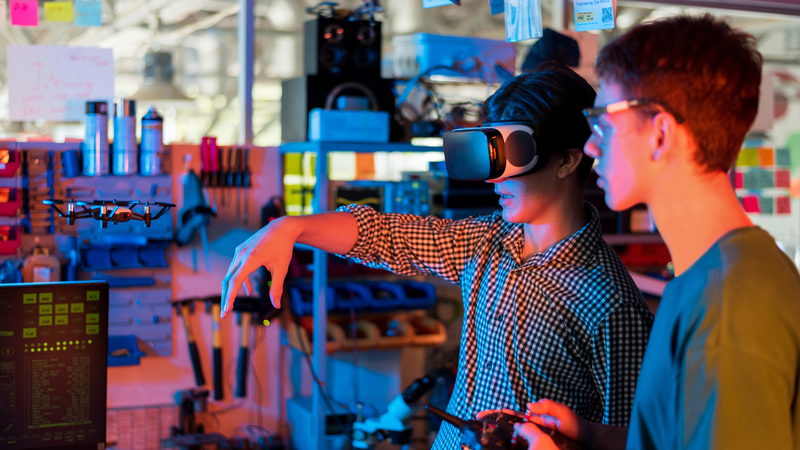 Teens doing experiments robotics laboratory boy protective glasses girl vr headset